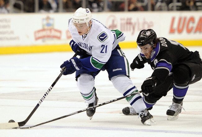 LOS ANGELES, CA - APRIL 01:  Mason Raymond #21 of the Vancouver Canucks has the puck knocked away from behind by Drew Doughty #8 of the Los Angeles Kings during the first period at the Staples Center on April 1, 2010 in Los Angeles, California.  (Photo by Harry How/Getty Images)