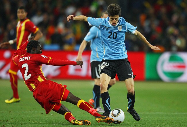 JOHANNESBURG, SOUTH AFRICA - JULY 02: Hans Sarpei of Ghana tackles Alvaro Fernandez of Uruguay during the 2010 FIFA World Cup South Africa Quarter Final match between Uruguay and Ghana at the Soccer City stadium on July 2, 2010 in Johannesburg, South Africa.  (Photo by Cameron Spencer/Getty Images)