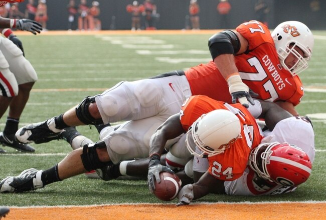 STILLWATER, OK - SEPTEMBER 5:  Running back Kendall Hunter #24 of the Oklahoma State Cowboys is stopped just short of the end zone as teammate Noah Franklin #77 falls on top during the third quarter of the game against the Georgia Bulldogs at Boone Pickens Stadium on September 5, 2009 in Stillwater, Oklahoma. (Photo by Christian Petersen/Getty Images)
