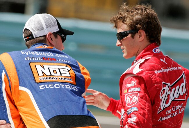 WATKINS GLEN, NY - AUGUST 07:  Kyle Busch (L), driver of the #18 M&Ms Toyota, talks with Kasey Kahne, driver of the #9 Budweiser Dodge, on the grid during qualifying for the NASCAR Sprint Cup Series Heluva Good! Sour Cream Dips at Watkins Glen International on August 7, 2009 in Watkins Glen, New York.  (Photo by Todd Warshaw/Getty Images for NASCAR)