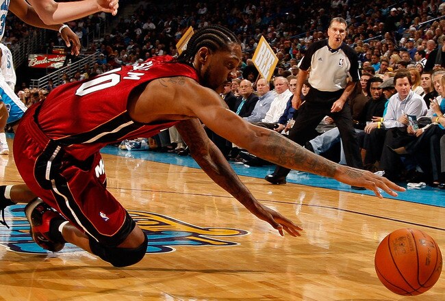 NEW ORLEANS - DECEMBER 30:  Udonis Haslem #40 of the Miami Heat dives for a lose ball around Daris Songaila #9 of the New Orleans Hornets at New Orleans Arena on December 30, 2009 in New Orleans, Louisiana.  The Hornets defeated the Heat 95-91.  NOTE TO USER: User expressly acknowledges and agrees that, by downloading and/or using this Photograph, User is consenting to the terms and conditions of the Getty Images License Agreement.  (Photo by Chris Graythen/Getty Images)
