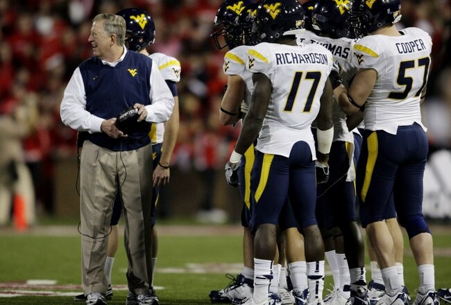 CINCINNATI - NOVEMBER 13:  Head coach Bill Stewart of the West Virginia Mountaineers meets with his team against the Cincinnati Bearcats in the second quarter at Nippert Stadium on November 13, 2009 in Cincinnati, Ohio.  (Photo by Andy Lyons/Getty Images)