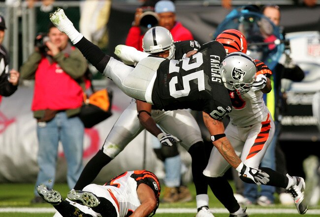 OAKLAND, CA - NOVEMBER 22:  Justin Fargas #25 of the Oakland Raiders flips in the air after being hit by the Cincinnati Bengals at Oakland-Alameda County Coliseum on November 22, 2009 in Oakland, California.  (Photo by Ezra Shaw/Getty Images)