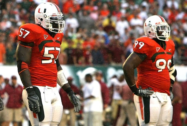 MIAMI - OCTOBER 04:  Defenders Adewale Ojomo #97, Antonio Dixon #96, Allen Bailey #57 and Marcus Forston #99 of the Miami Hurricanes wait for the next play while taking on the Florida State Seminoles at Dolphin Stadium on October 4, 2008 in Miami, Florida. Florida State defeated Miami 41-39.  (Photo by Doug Benc/Getty Images)