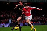 LONDON, ENGLAND - FEBRUARY 10:  Andrei Arshavin of Arsenal and Jamie Carragher of Liverpool battle for the ball during the Barclays Premier League match between Arsenal and Liverpool at Emirates Stadium on February 10, 2010 in London, England.  (Photo by Mike Hewitt/Getty Images)