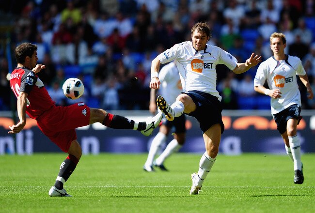 BOLTON, ENGLAND - AUGUST 14: Johan Elmander of Bolton battles for the ball with Aaron Hughes of Fulham  during the Barclays Premier League match between Bolton Wanderers and Fulham at Reebok Stadium on August 14, 2010 in Bolton, England.  (Photo by Laurence Griffiths/Getty Images)