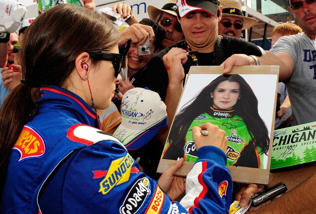 BROOKLYN, MI - AUGUST 14:  Danica Patrick, driver of the #7 Hot Wheels / GoDaddy.com Chevrolet, signs autographs for fans during qualifying for the NASCAR Nationwide Series CARFAX 250 at Michigan International Speedway on August 14, 2010 in Brooklyn, Michigan.  (Photo by Rusty Jarrett/Getty Images for NASCAR)