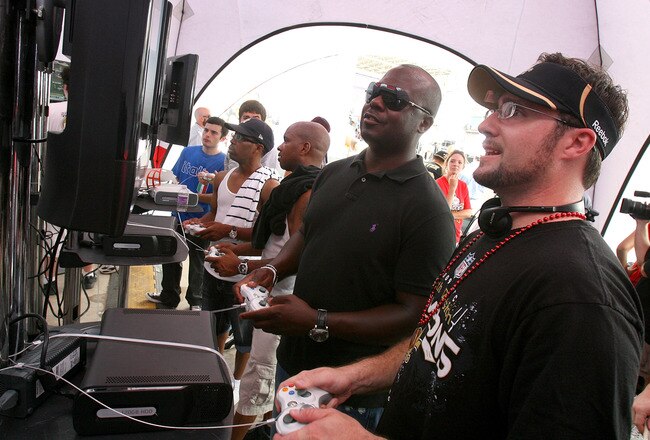 NEW ORLEANS - AUGUST 09:  NFL Legend Marshall Faulk (C) plays Madden NFL 11 against fans at Madden Gras, celebrating the kickoff of the popular video game on August 9, 2010 in New Orleans, Louisiana. The game featuring New Orleans Saints quarterback Drew Brees goes on sale in stores at midnight on August 10.  (Photo by Sean Gardner/Getty Images)