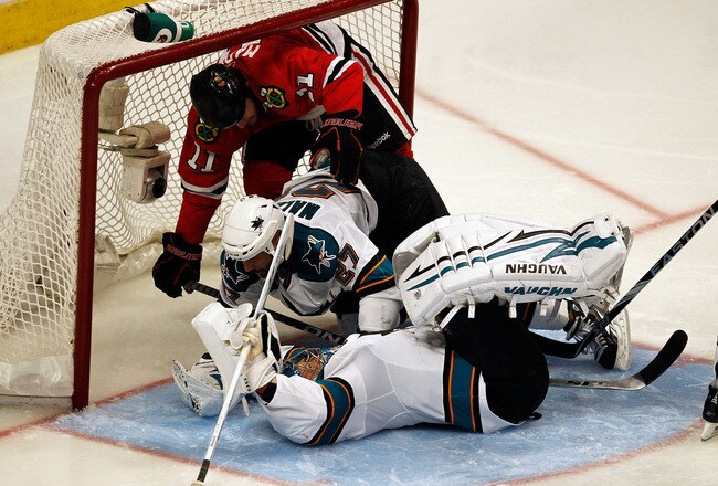 CHICAGO - MAY 23:  Goaltender Evgeni Nabokov #20 of the San Jose Sharks is knocked on his back as Manny Malhotra #27 of the San Jose Sharks checks John Madden #11 of the Chicago Blackhawks into the net in the third period of Game Four of the Western Conference Finals during the 2010 NHL Stanley Cup Playoffs at the United Center on May 23, 2010 in Chicago, Illinois.  (Photo by Jonathan Daniel/Getty Images)