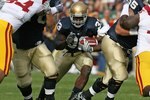 SOUTH BEND, IN - OCTOBER 17: Robert Hughes #33 of the Notre Dame Fighting Irish looks for running run against Armond Armstead #94 and DaJohn Harris #98 of the USC Trojans at Notre Dame Stadium on October 17, 2009 in South Bend, Indiana. USC defeated Notre Dame 34-27. (Photo by Jonathan Daniel/Getty Images)
