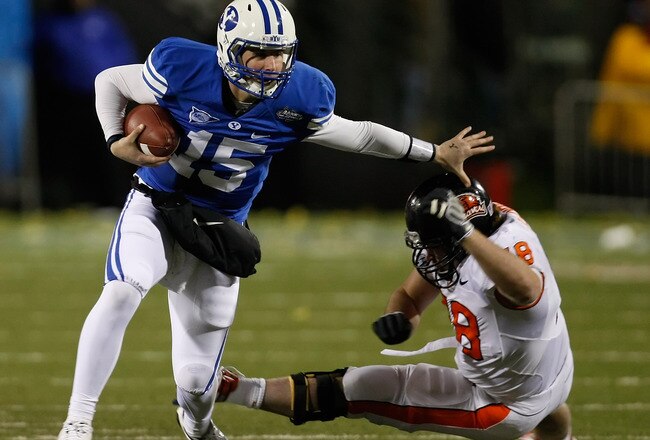 LAS VEGAS - DECEMBER 22:  Quarterback Max Hall #15 of the Brigham Young University Cougars runs for yardage against Ben Motter #78 of the Oregon State Beavers during the MAACO Las Vegas Bowl at Sam Boyd Stadium December 22, 2009 in Las Vegas, Nevada.  (Photo by Ethan Miller/Getty Images)