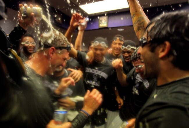DENVER - OCTOBER 01:  Manager Jim Tracy (L) of the Colorado Rockies is showered by his teammates as they celebrate in the clubhouse after they defeated the Milwaukee Brewers 9-2 and clinched a National League playoff berth at Coors Field on October 1, 2009 in Denver, Colorado.  (Photo by Doug Pensinger/Getty Images)