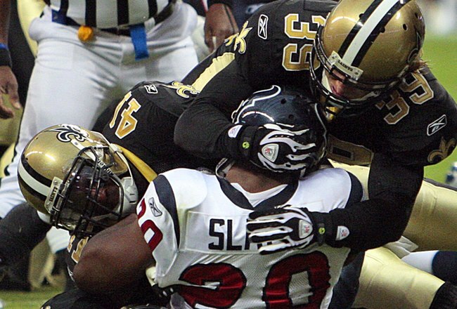 HOUSTON - AUGUST 22:  Running back Steve Slaton #20 of the Houston Texans is tackled by Chris Reis #39, Tracy Porter #22 and Roman Harper #41 of the New Orleans Saints on August 22, 2009 in Houston, Texas.  (Photo by Bob Levey/Getty Images)