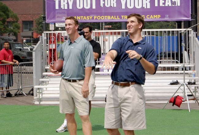 Peyton Manning and Eli Manning throw passes to fans at the 2005 Fantasy Football Training Camp held at the South Street Seaport on July 18, 2005 in New York City (Photo by Jemal Countess/Getty Images)