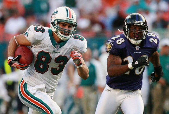 MIAMI - DECEMBER 16:  Wide receiver Greg Camarillo #83 of the Miami Dolphins breaks away from defensive back Jamaine Winborne #28 of the Baltimore Ravens for the game winning touchdown in overtime at Dolphin Stadium on December 16, 2007 in Miami, Florida. The Dolphins defeated the Ravens 22-16 for their first victory of the year.  (Photo by Doug Benc/Getty Images)