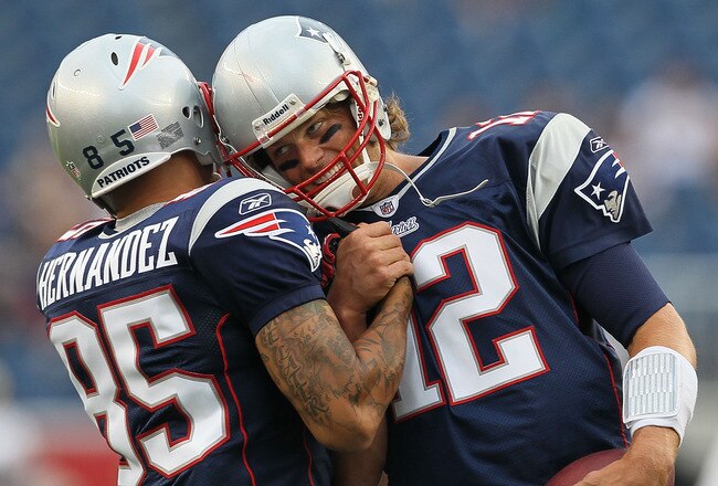 FOXBORO, MA - AUGUST 12: Aaron Hernandez  #85 and Tom Brady #12 of the New England Patriots greet each other before the the preseason game against the New Orleans Saints at Gillette Stadium on August 12, 2010 in Foxboro. Massachusetts. (Photo by Jim Rogash/Getty Images)