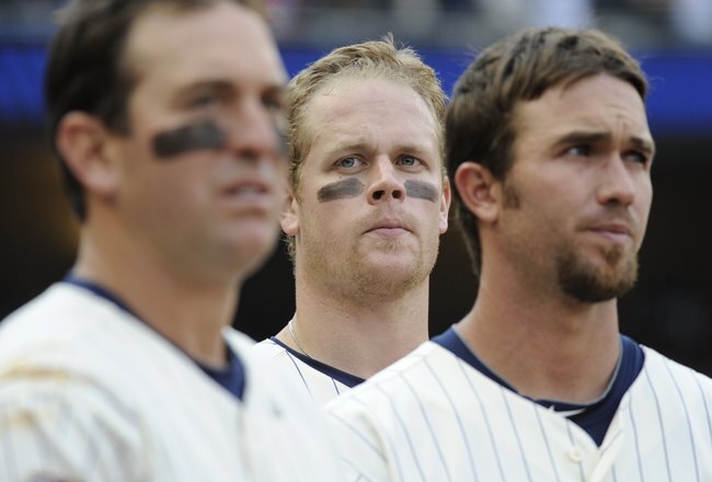 MINNEAPOLIS, MN - APRIL 12: Left to right, Nick Punto #8, Justin Morneau #33 and J.J. Hardy #27 of the Minnesota Twins during the singing of God Bless America in the middle of the seventh inning in a game against the Boston Red Sox during the Twins home opener at Target Field on April 12, 2010 in Minneapolis, Minnesota. (Photo by Hannah Foslien /Getty Images)