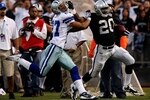 OAKLAND, CA - AUGUST 13:  Running back Darren McFadden #20 of the Oakland Raiders gives a stiff arm during a second quarter run against Courtney Brown #27 of the Dallas Cowboys during the preseason game at Oakland-Alameda County Coliseum on August 13, 2009 in Oakland, California. (Photo by Jed Jacobsohn/Getty Images)