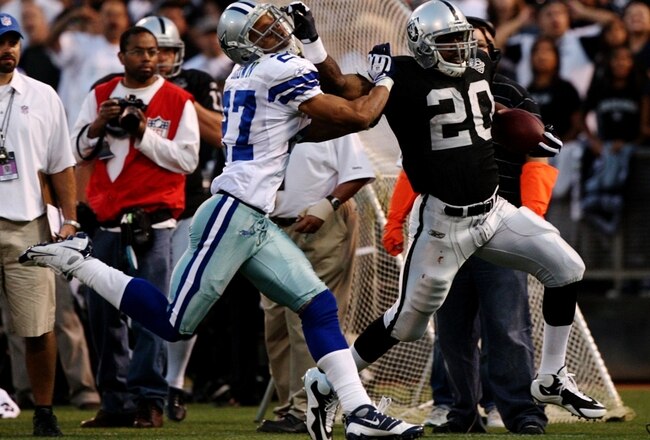OAKLAND, CA - AUGUST 13:  Running back Darren McFadden #20 of the Oakland Raiders gives a stiff arm during a second quarter run against Courtney Brown #27 of the Dallas Cowboys during the preseason game at Oakland-Alameda County Coliseum on August 13, 2009 in Oakland, California. (Photo by Jed Jacobsohn/Getty Images)