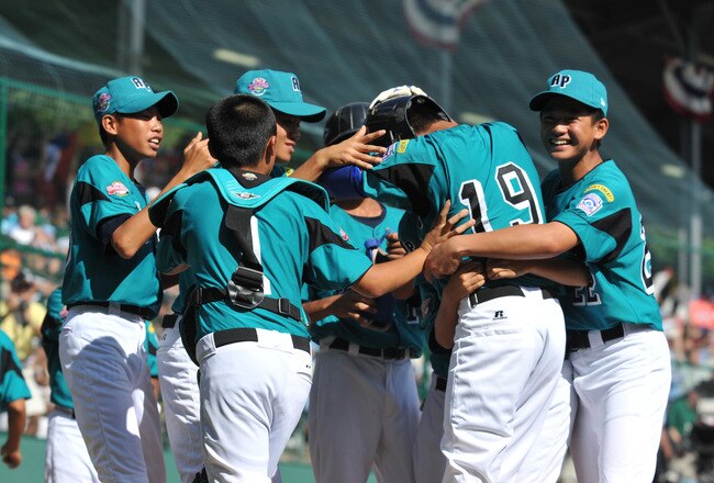 WILLIAMSPORT, PA - AUGUST 30: First baseman Wen Hua Sung #19 of Asia Pacific (Taoyuan, Taiwan) is mobbed by teammates after a home run against California (Chula Vista) in the little league world series final at Lamade Stadium on August 30, 2009 in Williamsport, Pennsylvania. (Photo by Larry French/Getty Images)