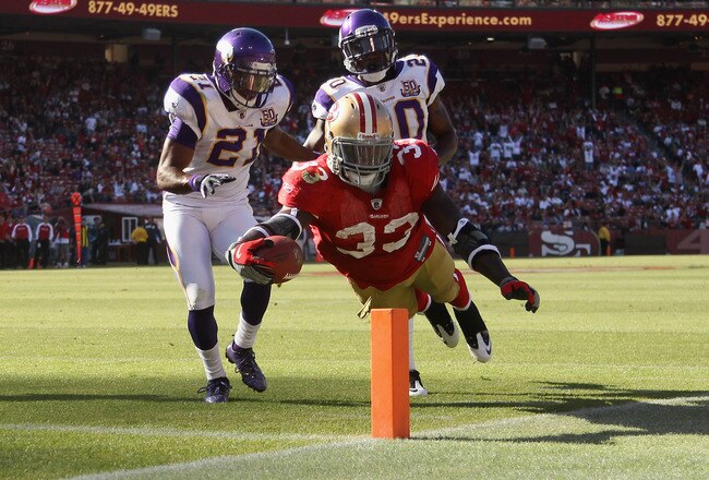 SAN FRANCISCO - AUGUST 22:  Anthony Dixon #33 of the San Francisco 49ers dives past Madieu Williams #20 and Asher Allen #21 of the Minnesota Vikings at Candlestick Park on August 22, 2010 in San Francisco, California.  (Photo by Ezra Shaw/Getty Images)