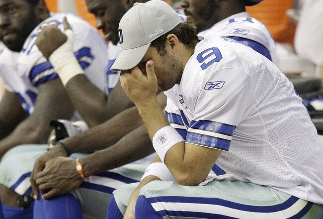 HOUSTON - AUGUST 28: Quarterback Tony Romo #9 of the Dallas Cowboys holds his head as he sits on the bench in the fourth quarter during a game against the Houston Texans at Reliant Stadium on August 28, 2010 in Houston, Texas. Houston won 23-7. (Photo by Bob Levey/Getty Images)