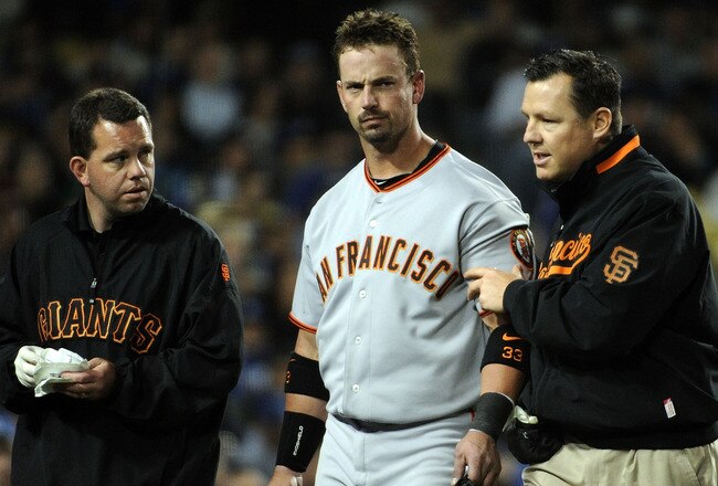 LOS ANGELES, CA - APRIL 16:  Aaron Rowand of the San Francisco Giants is helped off the field by trainers after being hit in the head by a pitch from Vicente Padilla of the Los Angeles Dodgers during the fifth inning at Dodger Stadium on April 16, 2010 in Los Angeles, California. The players are all wearing number 42 in honor of Jackie Robinson.  (Photo by Harry How/Getty Images)
