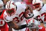 COLUMBUS, OH - OCTOBER 10:  Running back John Clay #32 of the Wisconsin Badgers hops away from the grasp of Ross Homan #51 of the Ohio State Buckeyes at Ohio Stadium on October 10, 2009 in Columbus, Ohio.  (Photo by Jamie Sabau/Getty Images)