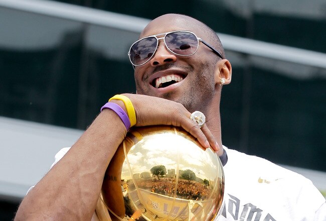 LOS ANGELES, CA - JUNE 21:  Los Angeles Lakers guard Kobe Bryant laughs with the championship trophy while riding in the victory parade for the the NBA basketball champion team on June 21, 2010 in Los Angeles, California. The Lakers beat the Boston Celtics 87-79 in 7 games for the franchise's 16 NBA title.  (Photo by Noel Vasquez/Getty Images)