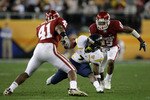 GLENDALE, AZ - JANUARY 02:  Noel Devine #7 of the West Virginia Mountaineers tries to elude Darien Williams #41 and Dominique Franks #15 of the Oklahoma Sooners after gaining 13-yards on a pass reception in the first quarter at the Tostito's Fiesta Bowl at University of Phoenix Stadium January 2, 2008 in Glendale, Arizona.  (Photo by Doug Pensinger/Getty Images)