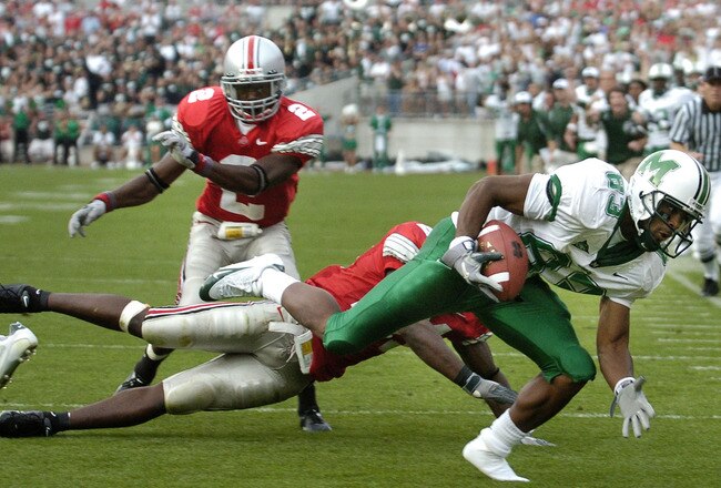 COLUMBUS, OH - SEPTEMBER 11:  Brad Bates #83 of the Marshall Thundering Herd loses his shoe as he scores a touchdown against Ohio State in the fourth quarter on September 11, 2004 at Ohio Stadium in Columbus, Ohio.  Defending on the play are Ohio State players Nate Salley #21 and Erik Haw #2.  Ohio State defeated Marshall 24-21.   (Photo by David Maxwell/Getty Images)
