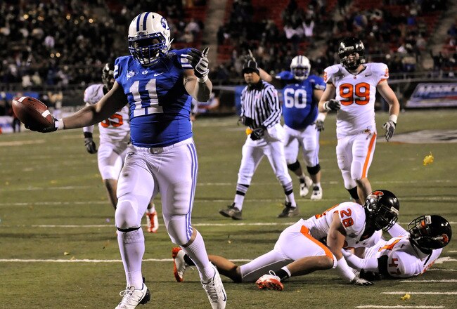 LAS VEGAS - DECEMBER 22:  Manase Tonga #11 of the Brigham Young University Cougars scores a touchdown in the fourth quarter after getting by defenders including Suaesi Tuimaunei #28 and Anthony Watkins #47 of the Oregon State Beavers during the MAACO Las Vegas Bowl at Sam Boyd Stadium December 22, 2009 in Las Vegas, Nevada. The Cougars won 44-20.  (Photo by Ethan Miller/Getty Images)