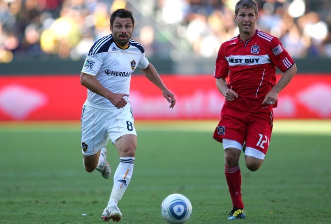 CARSON, CA - AUGUST 01:  Dema Kovalenko #8 of the Los Angeles Galaxy runs to the ball under pressure from Logan Pause #12 of the Chicago Fire in the second half of their MLS match at The Home Depot Center on August 1, 2010 in Carson, California. The Fire defeated the Galaxy 3-2.  (Photo by Victor Decolongon/Getty Images)