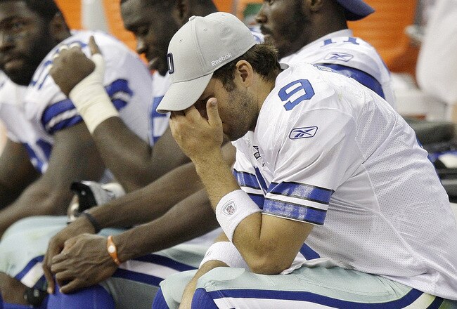 HOUSTON - AUGUST 28: Quarterback Tony Romo #9 of the Dallas Cowboys holds his head as he sits on the bench in the fourth quarter during a game against the Houston Texans at Reliant Stadium on August 28, 2010 in Houston, Texas. Houston won 23-7. (Photo by Bob Levey/Getty Images)