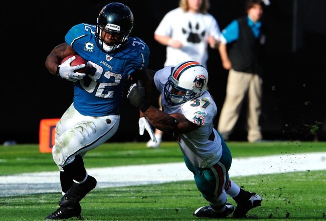 JACKSONVILLE, FL - DECEMBER 13:  Yeremiah Bell #37 of the Miami Dolphins attempts to tackle Maurice Jones-Drew #32 of the Jacksonville Jaguars during the game at Jacksonville Municipal Stadium on December 13, 2009 in Jacksonville, Florida.  (Photo by Sam Greenwood/Getty Images)