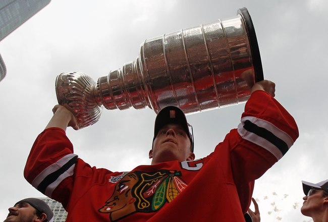 CHICAGO - JUNE 11: Jonathan Toews #19 hoists the cup during the Chicago Blackhawks Stanley Cup victory parade and rally on June 11, 2010 in Chicago, Illinois. (Photo by Jonathan Daniel/Getty Images)
