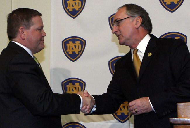 SOUTH BEND, IN - DECEMBER 11: Notre Dame atheletic director Jack Swarbrick (R) greets Brian Kelly as he is introduced as the new football head coach at Notre Dame University on December 11, 2009 in South Bend, Indiana.  Kelly most recently led the University of Cincinnati to two consecutive Bowl Championship Series appearances including a perfect 12-0 record this past season. (Photo by Frank Polich/Getty Images)