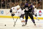 LOS ANGELES, CA - FEBRUARY 11:  Mike Comrie #91 of the Edmonton Oilers passes the puck under pressure from Anze Kopitar #11 of the Los Angeles Kings during their NHL game at the Staples Center on February 11, 2010 in Los Angeles, California. The Oilers defeated the Kings 3-2 in shootout overtime.  (Photo by Victor Decolongon/Getty Images)