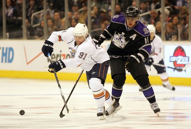 LOS ANGELES, CA - FEBRUARY 11:  Mike Comrie #91 of the Edmonton Oilers passes the puck under pressure from Anze Kopitar #11 of the Los Angeles Kings during their NHL game at the Staples Center on February 11, 2010 in Los Angeles, California. The Oilers defeated the Kings 3-2 in shootout overtime.  (Photo by Victor Decolongon/Getty Images)