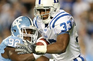 CHAPEL HILL, NC - NOVEMBER 07:  Desmond Scott #33 of the Duke Blue Devils is tackled by E.J. Wilson #92 of the North Carolina Tar Heels during their game at Kenan Stadium on November 7, 2009 in Chapel Hill, North Carolina.  (Photo by Streeter Lecka/Getty Images)