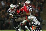 LONDON, ENGLAND - OCTOBER 25:  Derrick Ward (#28) of Tampa Bay Buccaneers is tackled by Leigh Bodden (#23) and Pat Chung (#25) of the New England Patriots during the NFL International Series match between New England Patriots and Tampa Bay Buccaneers at Wembley Stadium on October 25, 2009 in London, England. This is the third occasion where a regular season NFL match has been played in London.  (Photo by Elsa/Getty Images)