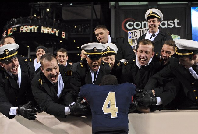 PHILADELPHIA - DECEMBER 12: Quarterback Ricky Dobbs #4 of the Navy Midshipmen, and game MVP, jumps into the crowd after their 17-3 victory over the Army Black Knights on December 12, 2009 at Lincoln Financial Field in Philadelphia, Pennsylvania. (Photo by Drew Hallowell/Getty Images)