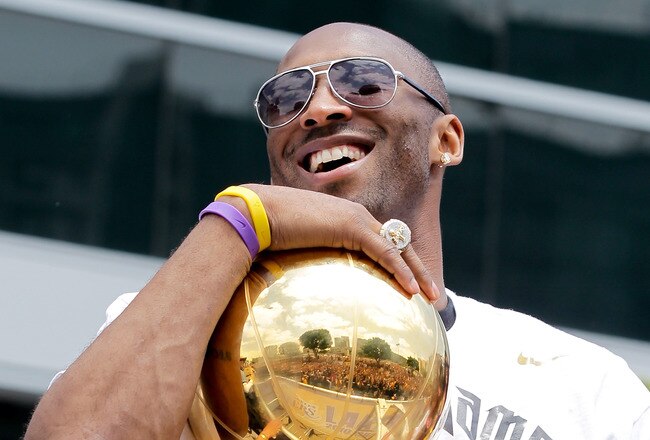 LOS ANGELES, CA - JUNE 21:  Los Angeles Lakers guard Kobe Bryant laughs with the championship trophy while riding in the victory parade for the the NBA basketball champion team on June 21, 2010 in Los Angeles, California. The Lakers beat the Boston Celtics 87-79 in 7 games for the franchise's 16 NBA title.  (Photo by Noel Vasquez/Getty Images)