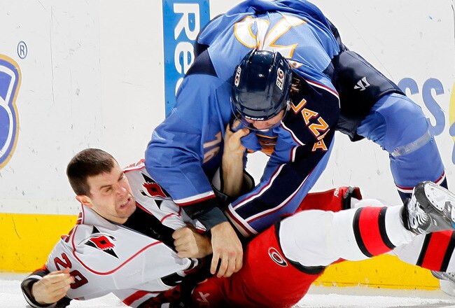 ATLANTA - MARCH 29:  Evgeny Artyukhin #76 of the Atlanta Thrashers knocks down Tom Kostopoulos #29 of the Carolina Hurricanes at Philips Arena on March 29, 2010 in Atlanta, Georgia.  (Photo by Kevin C. Cox/Getty Images)