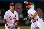 ST. LOUIS - SEPTEMBER 3: Pedro Feliz #77 of the St. Louis Cardinals throws to first base as teammate Brendan Ryan #13 backs him up against the Cincinnati Reds at Busch Stadium on September 3, 2010 in St. Louis, Missouri.  (Photo by Dilip Vishwanat/Getty Images)