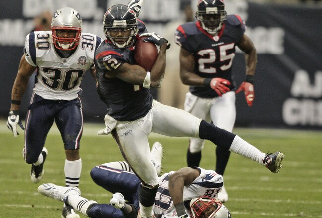 HOUSTON - JANUARY 03:  Kick returner Jacoby Jones #12 of  the Houston Texans avoids a tackle from Brandon McGowan #30 and Matthew Slater #18 of the New England Patriots at Reliant Stadium on January 3, 2010 in Houston, Texas.  (Photo by Bob Levey/Getty Images)