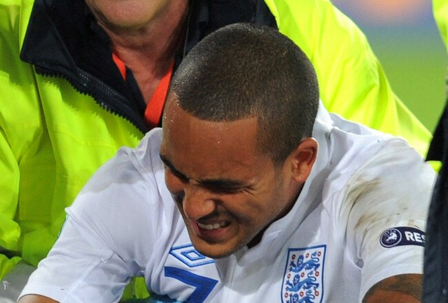 BASEL, SWITZERLAND - SEPTEMBER 07:  Theo Walcott of England grimaces as he receives treatment before being taken off injured during the EURO 2012 Qualifier between Switzerland and England at St Jakob Park on September 7, 2010 in Basel, Switzerland.  (Photo by Michael Regan/Getty Images)