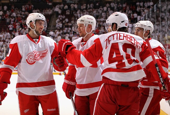 GLENDALE, AZ - APRIL 23:  Henrik Zetterberg #40 of the Detroit Red Wings is congratulated by teammates Drew Miller #20, Nicklas Lidstrom #13 and Valtteri Filppula #52 after Zetterberg scored an empty net goal against the Phoenix Coyotes in the third period of the Game Five of the Western Conference Quarterfinals during the 2010 NHL Stanley Cup Playoffs at Jobing.com Arena on April 23, 2010 in Glendale, Arizona. The Red Wings defeated the Coyotes 4-1 to take a 3-2 series lead. (Photo by Christian Petersen/Getty Images)