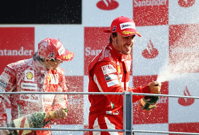 MONZA, ITALY - SEPTEMBER 12:  Race winner Fernando Alonso (R) of Spain and Ferrari celebrates on the podium with third placed team mate Felipe Massa (L) of Brazil and Ferrari following the Italian Formula One Grand Prix at the Autodromo Nazionale di Monza on September 12, 2010 in Monza, Italy.  (Photo by Paul Gilham/Getty Images)