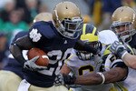 SOUTH BEND, IN - SEPTEMBER 11: Cierre Wood #20 of the Notre Dame Fighting Irish fights off Michigan Wolverine tacklers at Notre Dame Stadium on September 11, 2010 in South Bend, Indiana. Michigan defeated Notre Dame 28-24. (Photo by Jonathan Daniel/Getty Images)